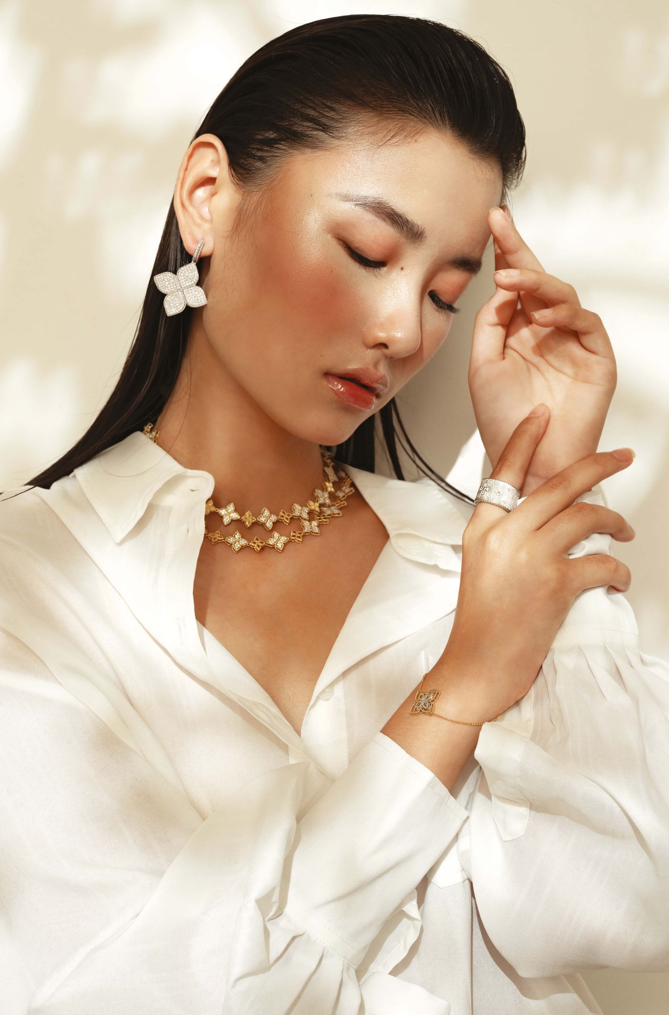 Venetian Princess ring, Princess Flower earrings in white gold set with diamonds and ruby signature; Princess Flower bracelet, necklace in yellow gold set with diamonds and ruby signature all by Roberto Coin; top by Dion Lee