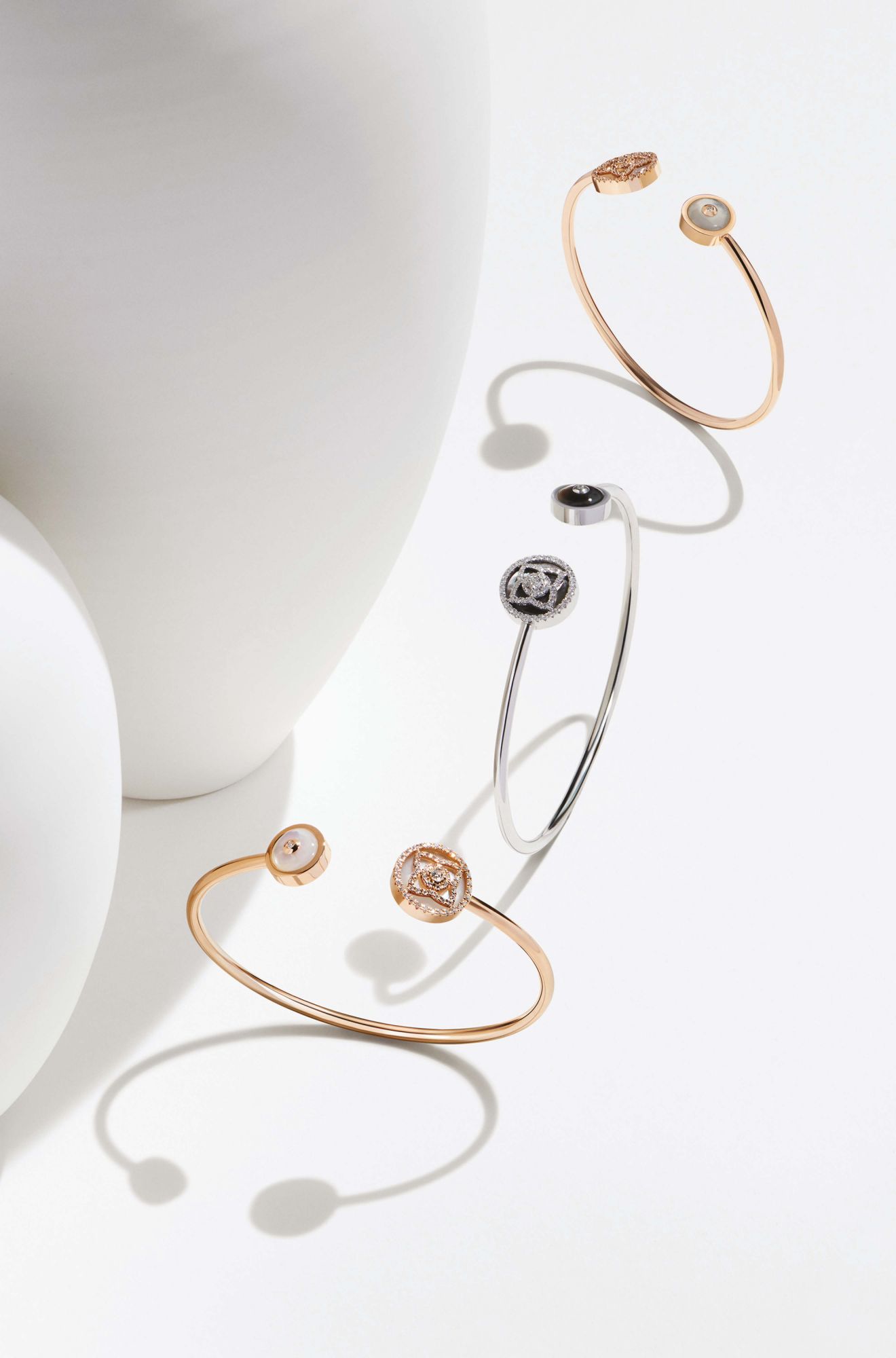 Enchanted Lotus bracelets in white gold set with grey mother-of-pearl and rose gold set with white mother-of-pearl, by De Beers. (Photo: Courtesy of De Beers)