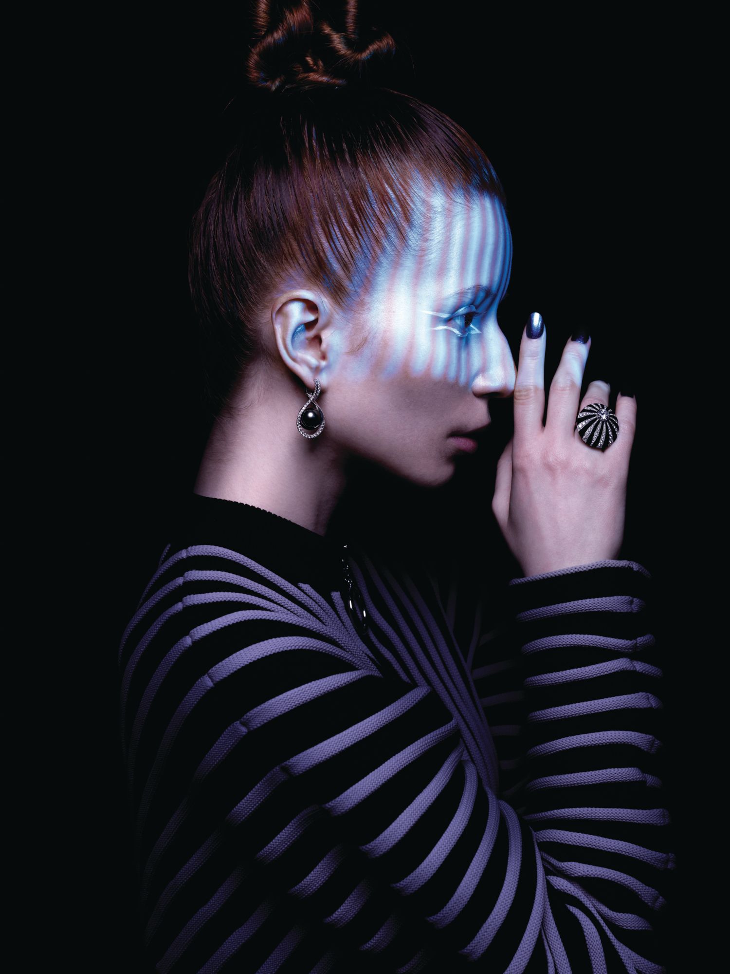 Earring in white gold set with a Black South Sea pearl and diamonds by Mikimoto; Wild Pop ring in white gold set with onyx elements and diamonds by Bulgari. Jumper by Louis Vuitton