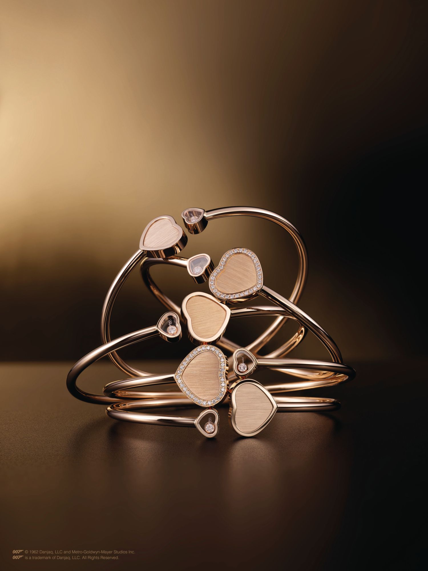 Chopard bangles in rose gold set with diamonds, all from the Happy Hearts—Golden Hearts collection.