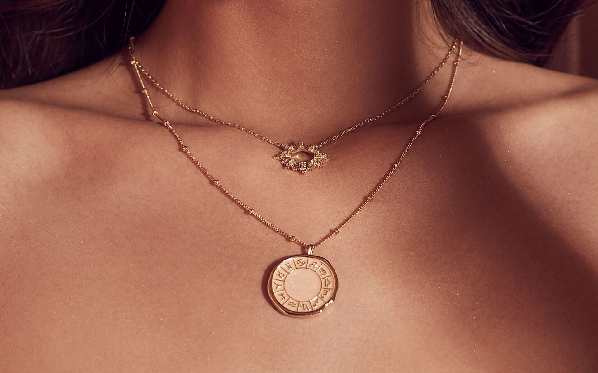 Highlighting the 12 Zodiac signs, the necklace, paired here with another necklace with a sunkeeper pendant, go perfectly with a classic tee. Photo courtesy of Wanderlust + Co