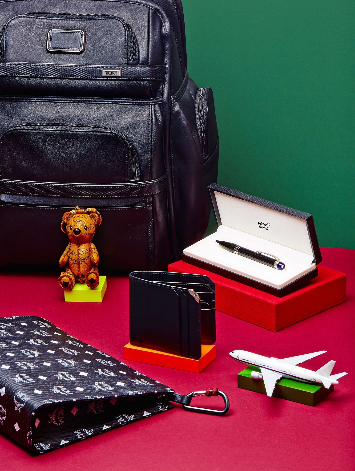 Alpha 3 Business Class Brief Pack, at Tumi; Teddy bear and clutch, at MCM; Meisterstück Urban wallet and pen, at Montblanc