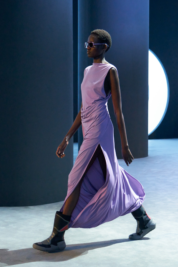 A draped jersey dress in pastel purple with a side slit revealing striking moon boots