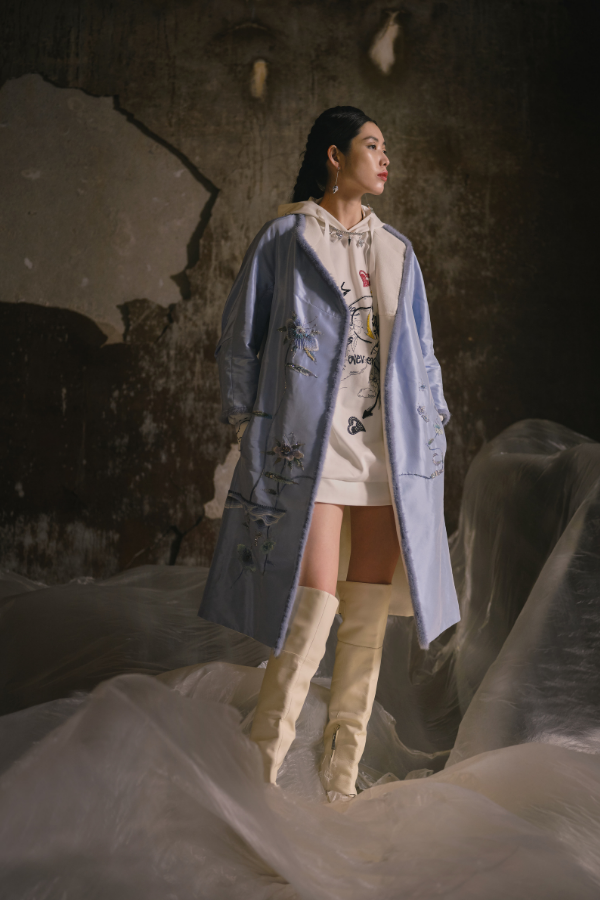 Casual hoodie styled with an oversized coat and knee-high boots