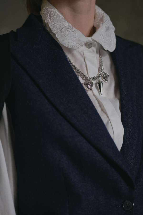 Glittering fabric and punk-inspired jewellery against a romantic embroidered collar bring out a rebel spirit