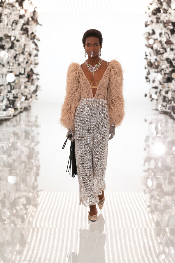 Old Hollywood meets the disco era with this low-cut ensemble, accented with sparkling jewellery