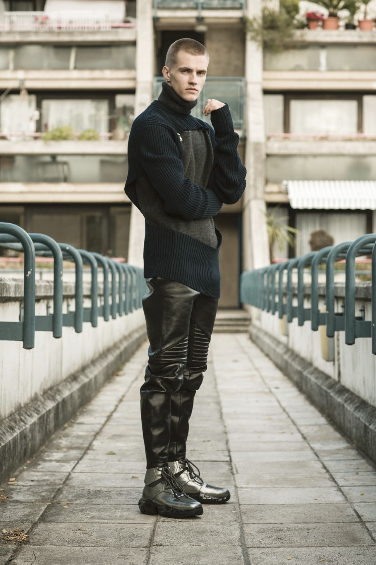 Grey sweater, navy sweater, brooch, and trousers by Bottega Veneta, boots by Jimmy Choo