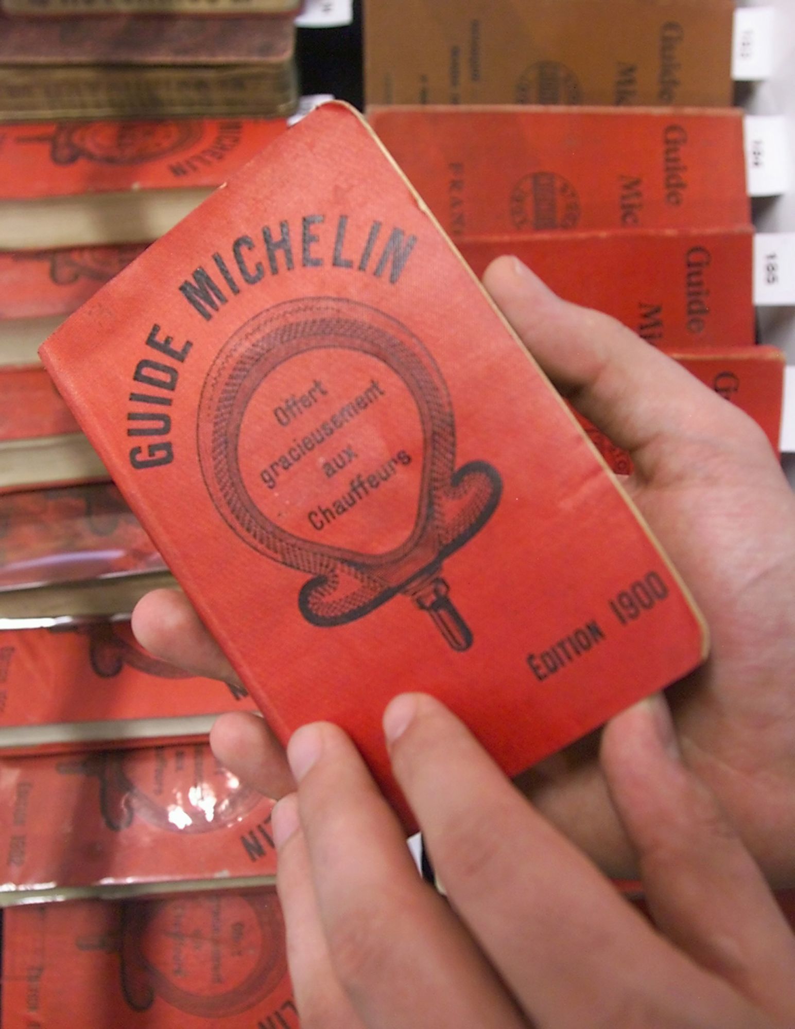 A first edition of the red Michelin guide is consulted 19 July 2000, one of the items in the first auction of Michelin memorabilia which wil be held 22 July in Clermont-Ferrand, where it is estimated to fetch 10 000 F (700 USD). (Photo by Eric CABANIS / AFP)