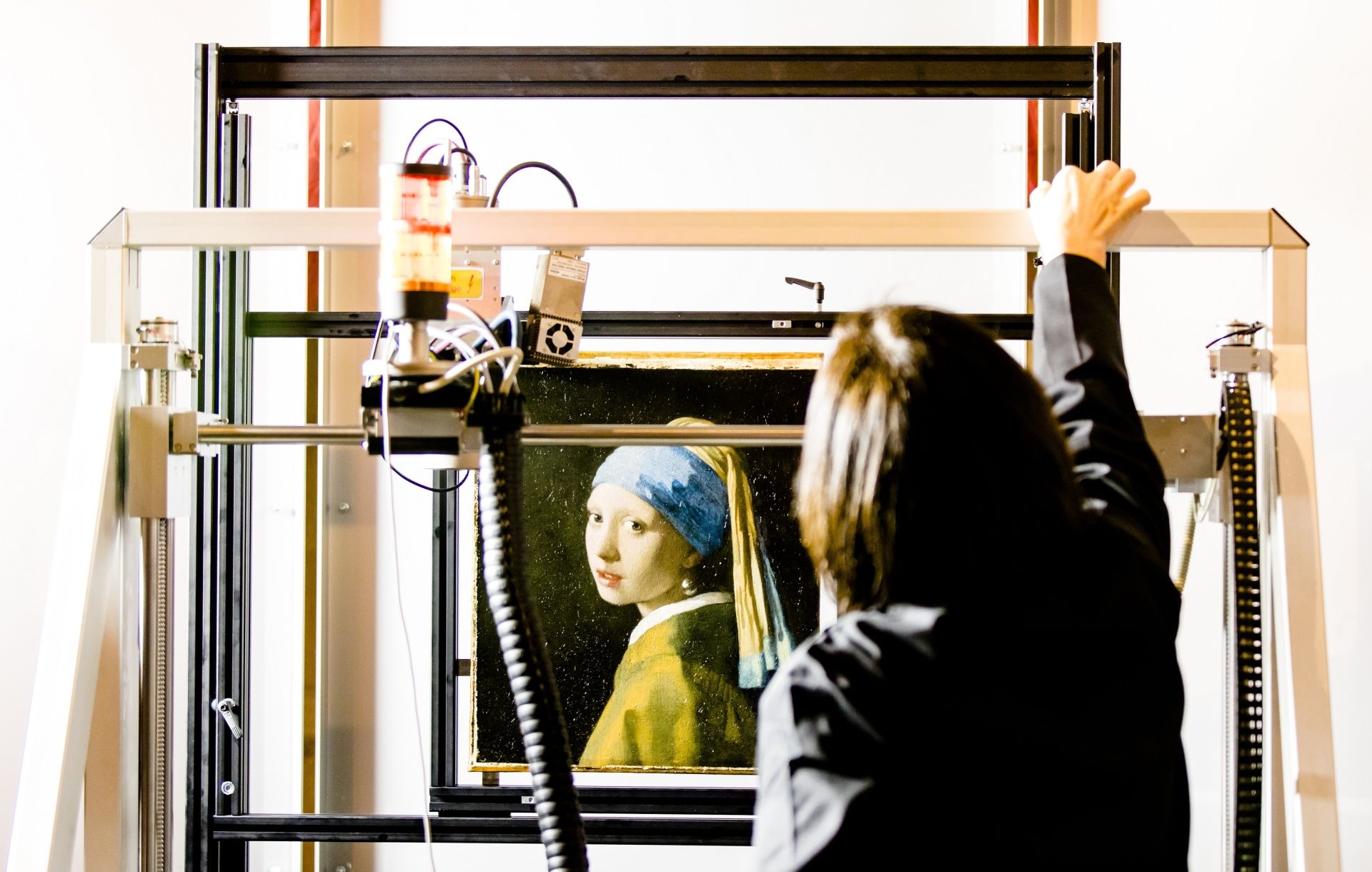 (FILES) In this file photo taken on february 26, 2018 hows Johannes Vermeer's Girl with a Pearl Earring painting inside a XRF macro-scanner during a research at The Mauritshuis in The Hague. - New researches carried out on Vermeer's ''Girl with the Pearl Earring'', one of the most famous paintings in the world, has unveiled discoveries that makes it more 'personal' even if the identity of the woman still remains a mystery, announced the museum on April 28, 2020. (Photo by Bart MAAT / ANP / AFP) / Netherla