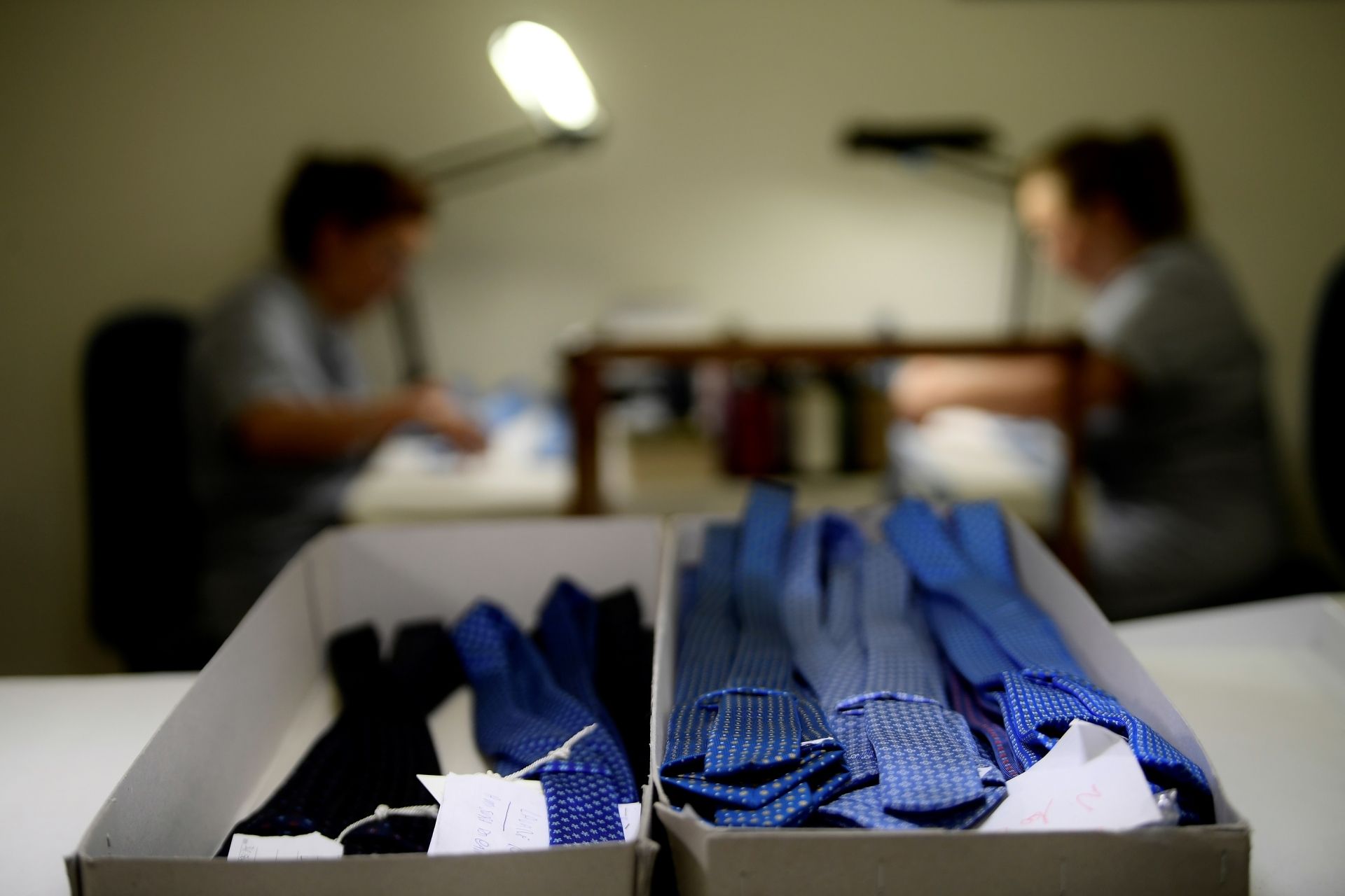 Finished bundles of ties sit in boxes as seamstresses work in the workshop of the "E. Marinella" shirt and tie makers family business in Naples on June 30, 2020. - Symbols of Italian elegance E.Marinella ties have been seen around the necks of Jacques Chirac, John Kennedy and Prince Charles. The ties which are entirely handmade are in greater demand than their production, in contrast to a market at half-mast. (Photo by FILIPPO MONTEFORTE / AFP)