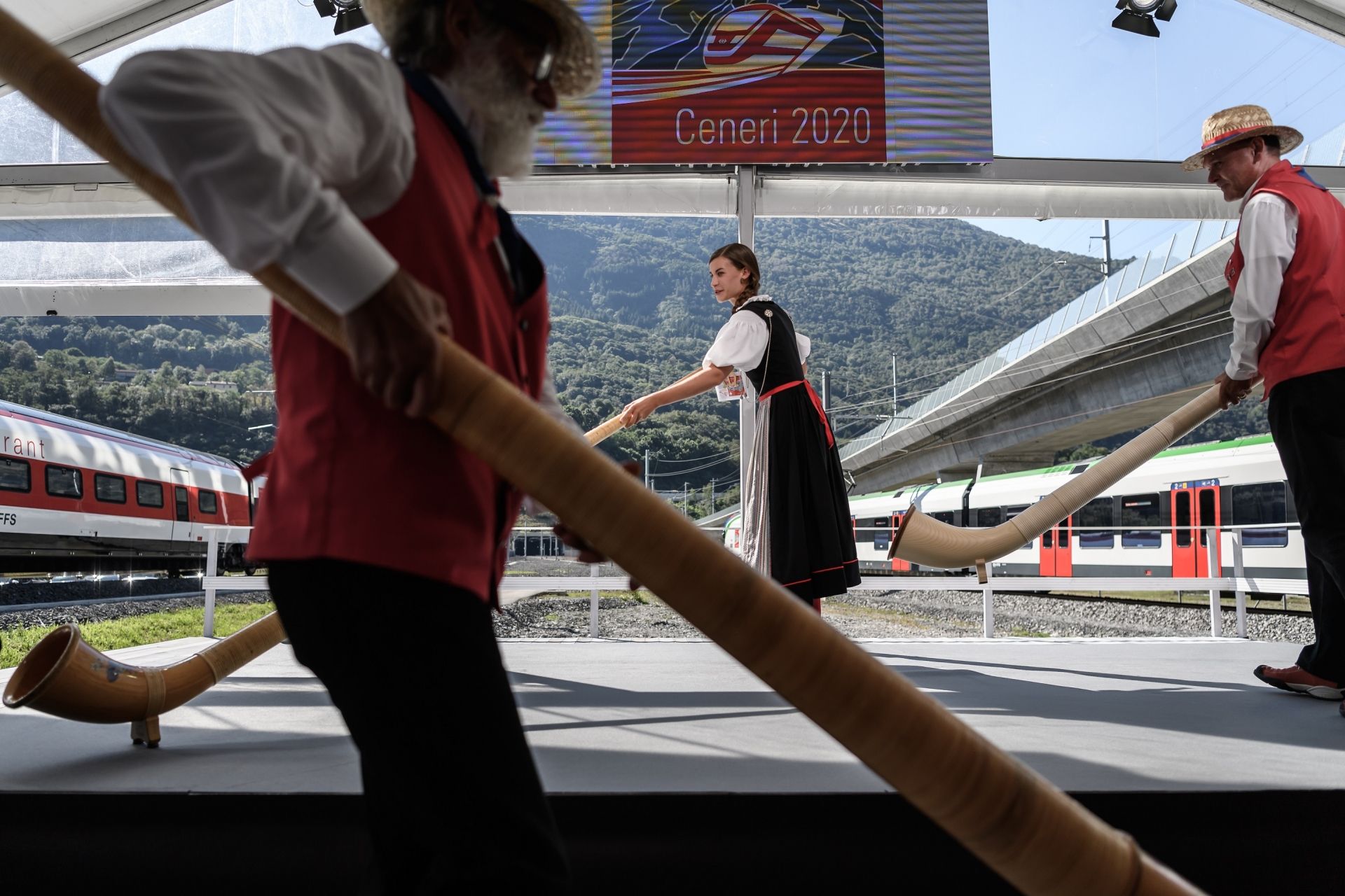 Alphorn blowers arrive on stage on September 4, 2020, in Camorino, southern Switzerland during the inauguration of the Ceneri Base railway tunnel, a two single-track 15,4 km long tunnel final part of the New Railway Link through the Alps (NRLA) construction project by Swiss autorities for faster rail links across the Alps aiming to mainly reduce transalpine truck traffic. - The rail service is expected to start in December 2020. (Photo by Fabrice COFFRINI / AFP)