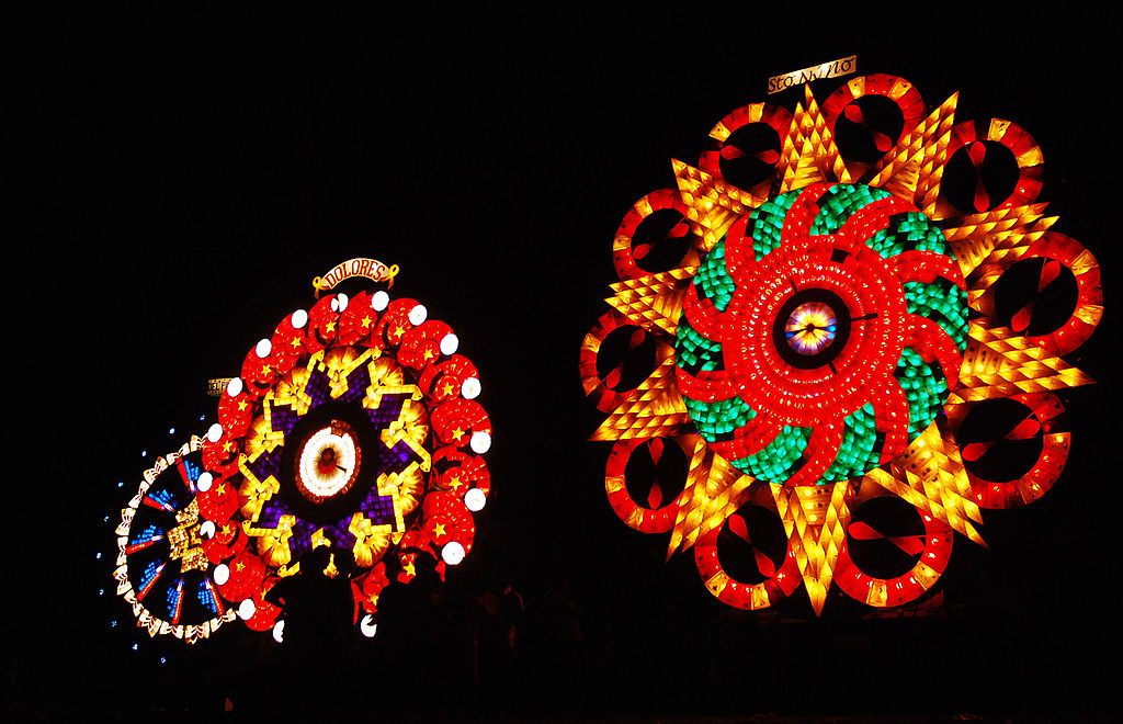 SAN FERNANDO, PHILIPPINES - DECEMBER 18: Spectators watch a light display during the Giant Lantern Festival on December 18, 2010 in San Fernando, Pampanga, Philippines. Giant lanterns averaging 20 feet in height and lit with at least 3,000 light bulbs will compete for the top prize in the competition, which has a tradition dating back to the mid 1920's. Pampanga is known as the Christmas capital of the Philippines and is famous for hosting the Giant Lantern Festival. (Photo by Dondi Tawatao/Getty Images)