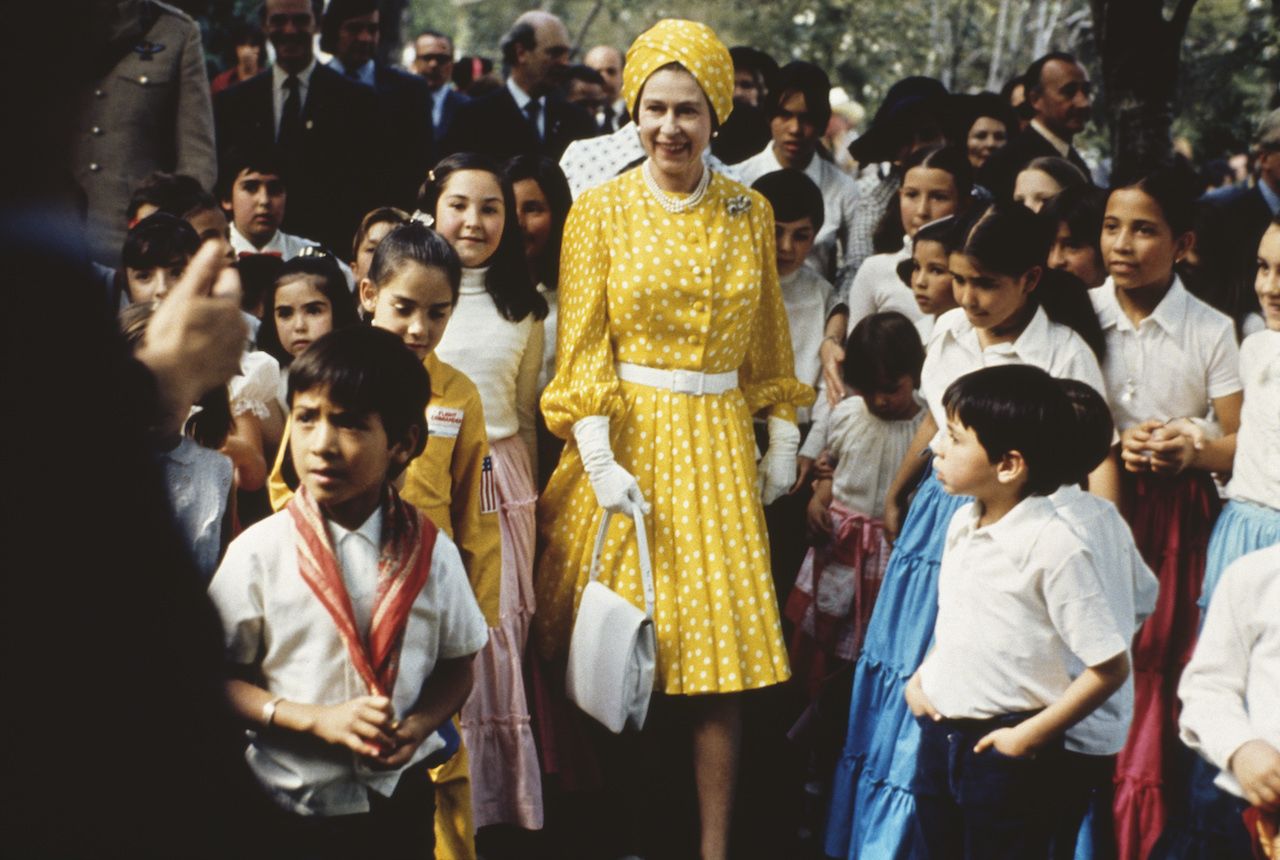Queen Elizabeth II with a group of local children during her state visit to Mexico, February-March 1975. (Photo by Serge Lemoine/Hulton Archive/Getty Images)