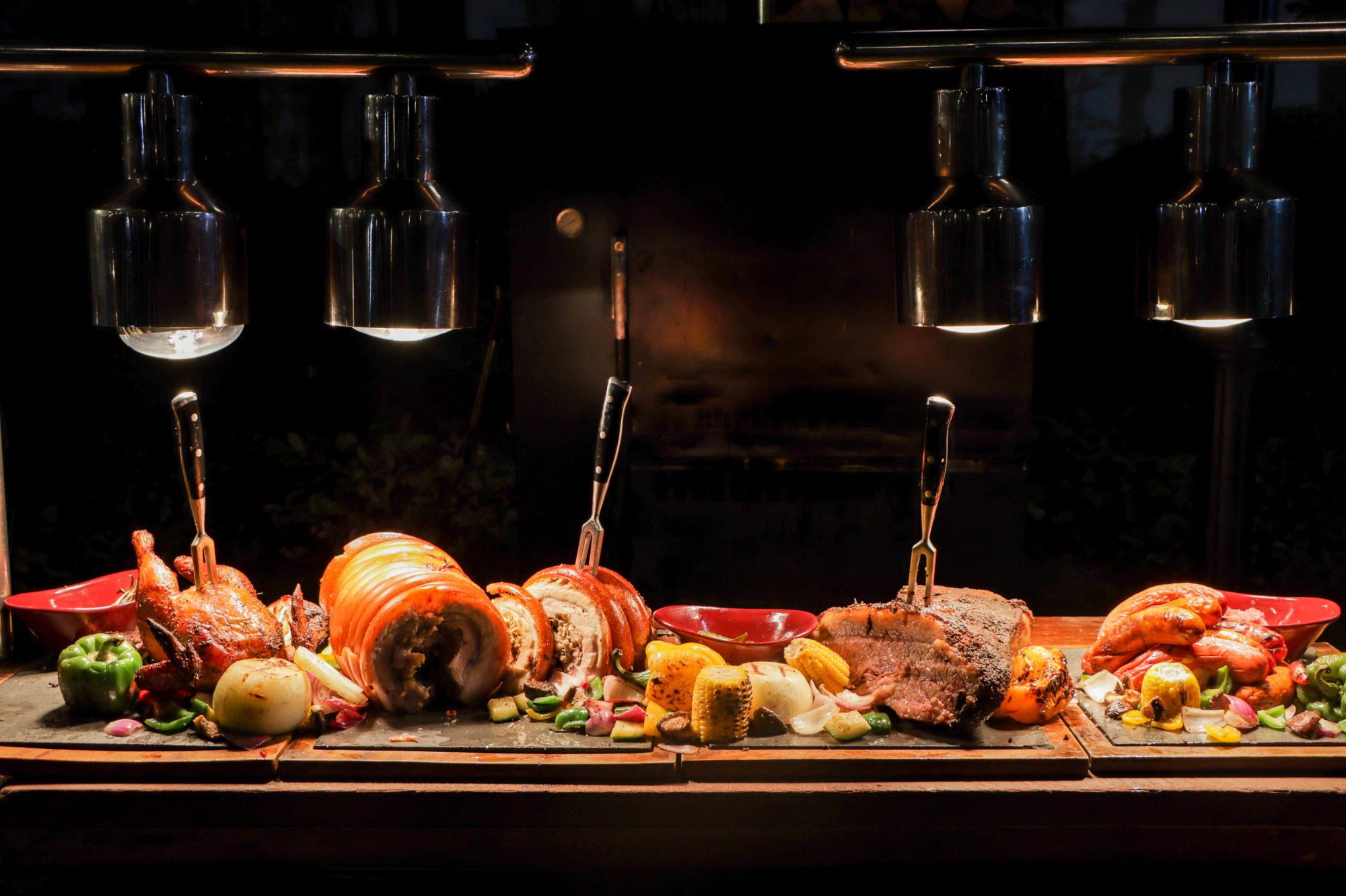 Succulent roast chicken, pork belly, and beef beautifully plated with an array of vegetables at Sofitel