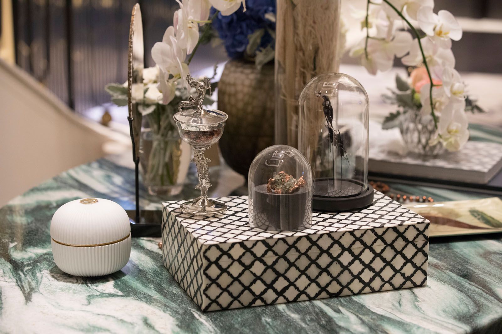 Accessories from Strange & Deranged and floral arrangement by Beato, displayed on the Hive marble table from MM Galleri