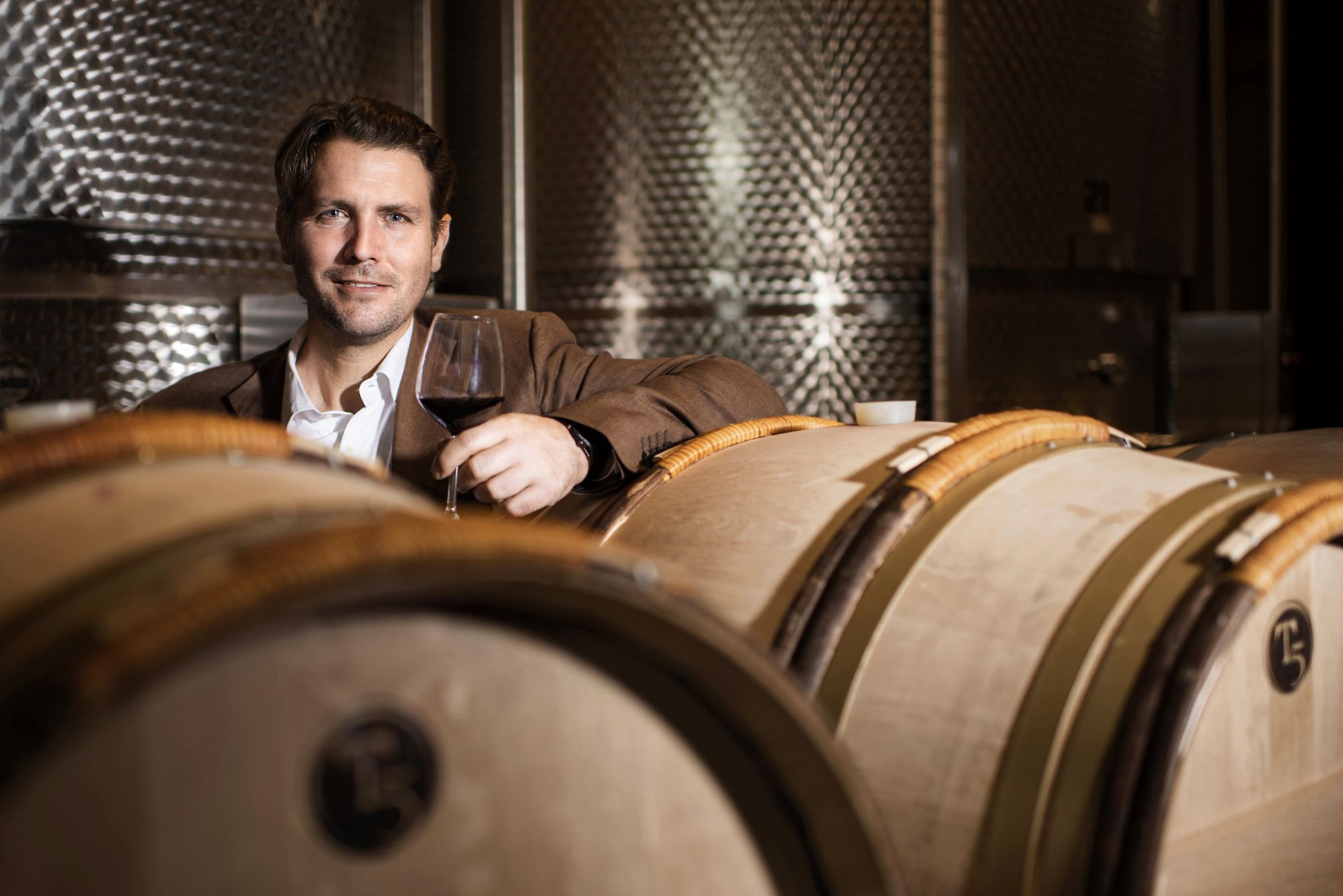 Salvatore Ferragamo, CEO of Il Borro, posing in between handmade wine barrels.
