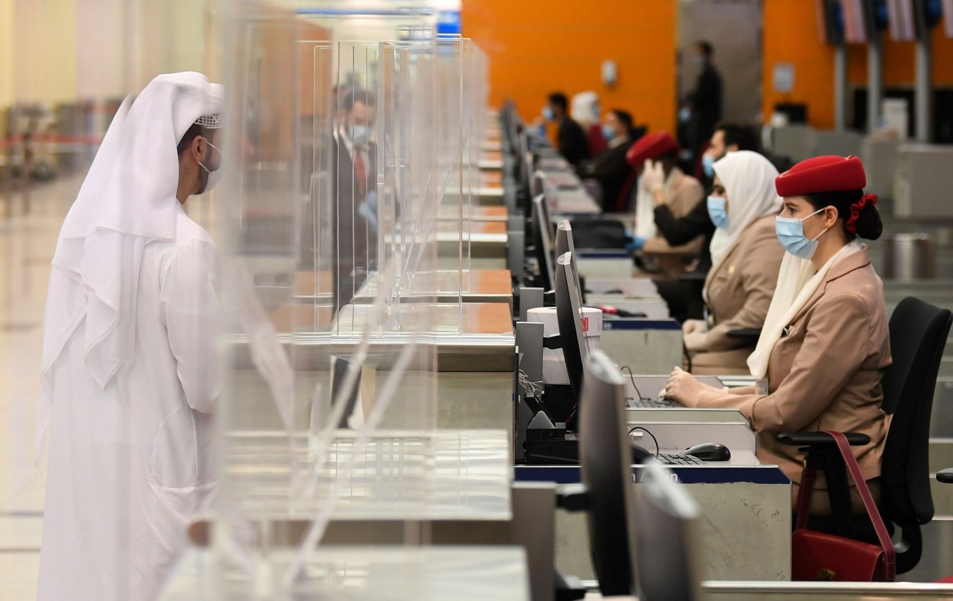 Passengers of an Emirates airlines flight departing to the Australian city of Sydney, check in at Dubai International Airport on May 22, 2020, after the resumption of scheduled operations by the Emirati carrier, amid the ongoing novel coronavirus pandemic crisis. (Photo by Karim SAHIB / AFP)