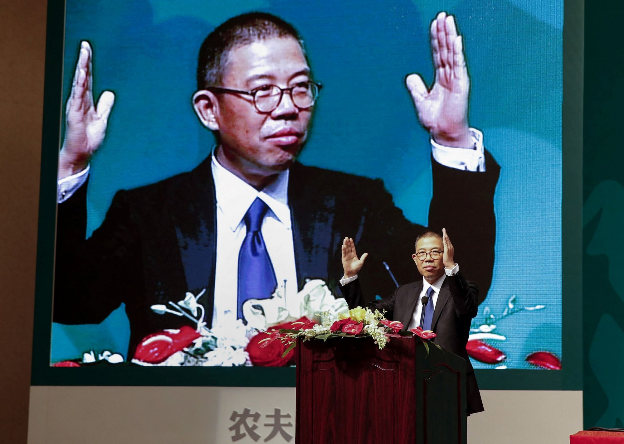 This photo taken on May 6, 2013 shows Zhong Shanshan, chairman of Nongfu Spring mineral water and a separate pharma company, gesturing during a speech at a press conference in Beijing. - Until recently, few people had even heard of the Chinese billionaire with a gruff reputation who built a fortune on China's seemingly unquenchable demand for his ubiquitous red-capped bottled water. (Photo by STR / CNS / AFP) / China OUT / TO GO WITH China-business-wealth-Asia,PROFILE by Helen Roxburgh and Danni Zhu
