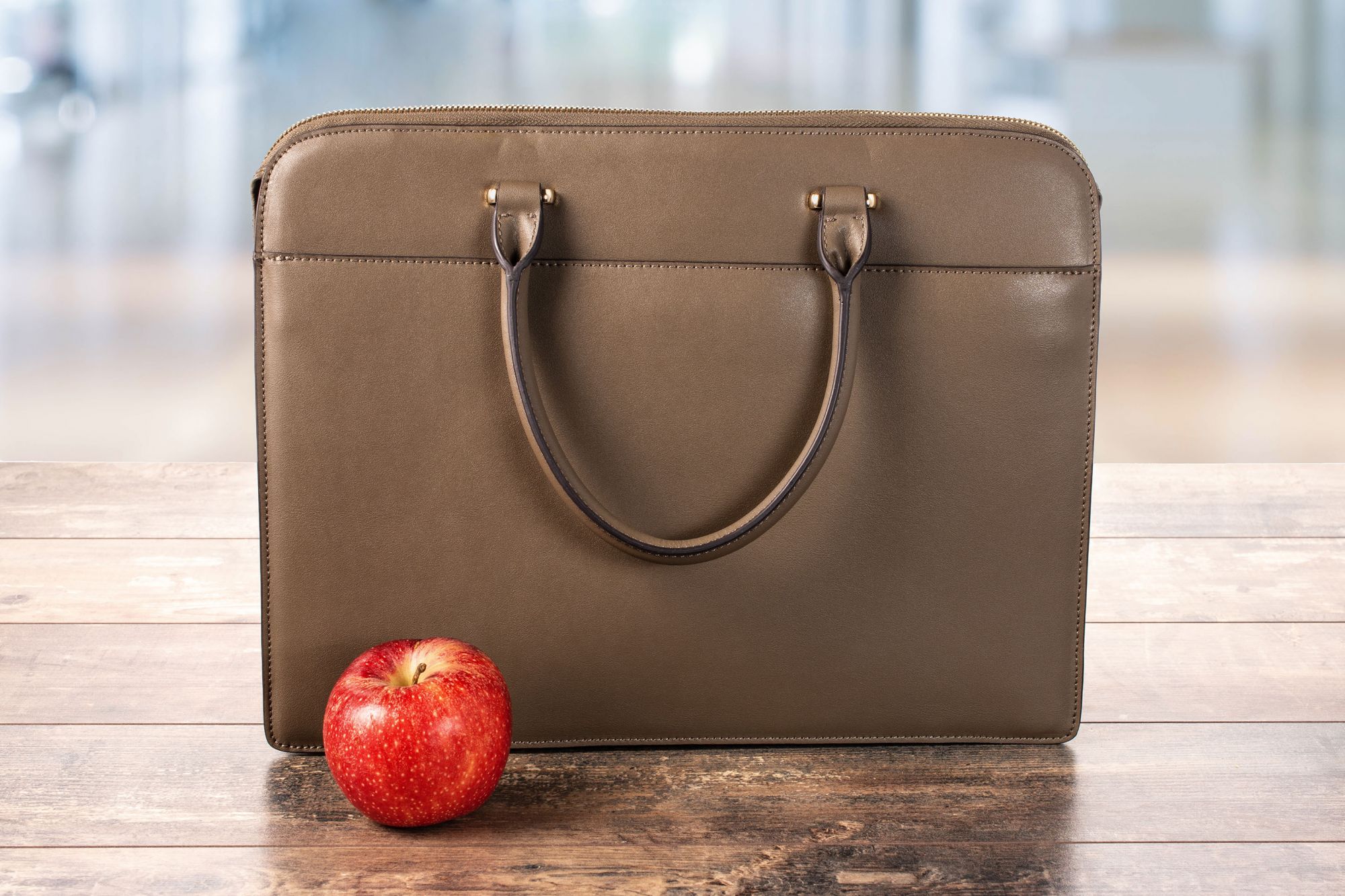 business bag, briefcase and red apple on a wooden table on a blurry background. proper nutrition at work in the office. Diet And healthy Food in the office; Shutterstock ID 1856322349; Purchase Order: ETX/Relaxnews/Fil; Client/Licensee: Arnaud POURPOINT