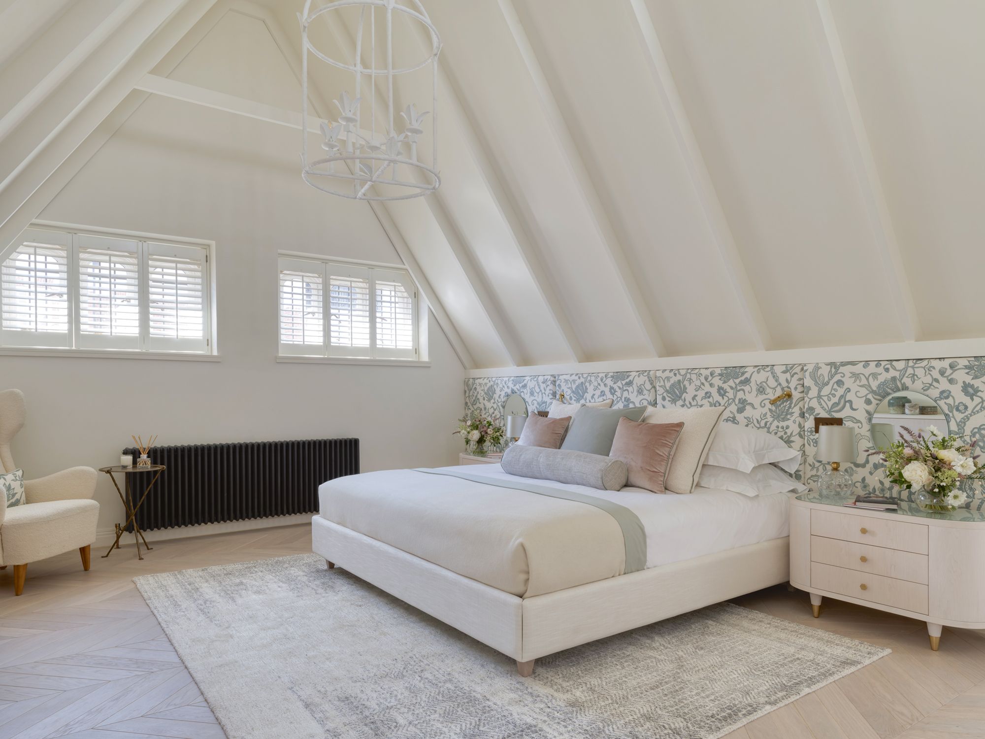 The master suite is furnished with bespoke nightstands, a white light fixture from The Lamp Workshop and an armchair by Gustav Bengtsson, designed in the forties