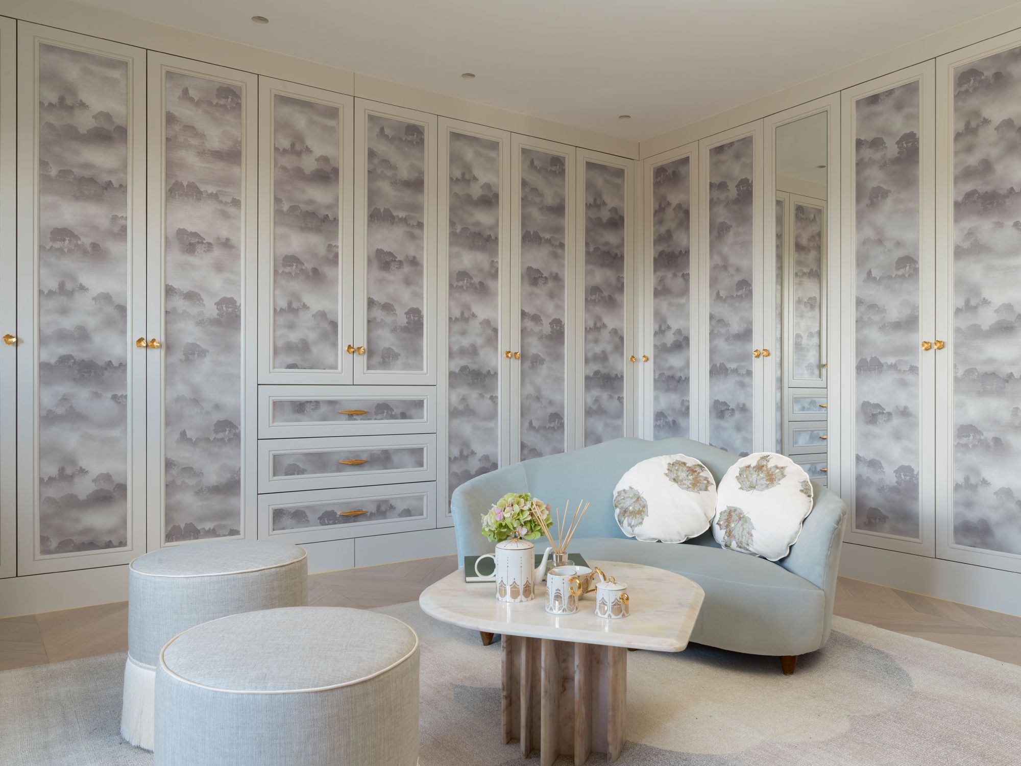 The master wardrobe features custom cabinetry with a dreamy pattern inspired by cloudy skies