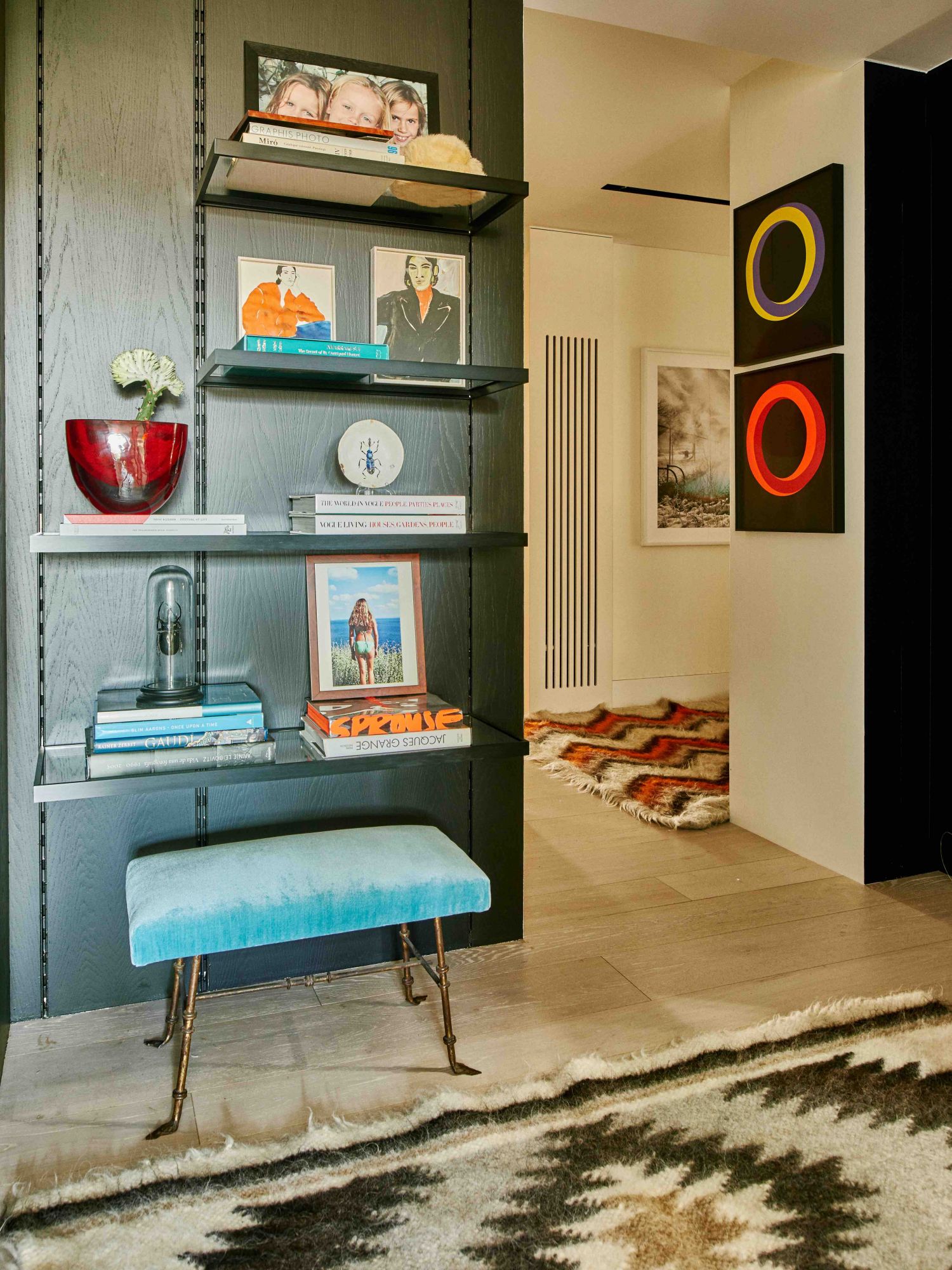 Un banc vintage de 177 Kensington et un souvenir coloré ajoutent des touches de couleur au mur en bois sombre
