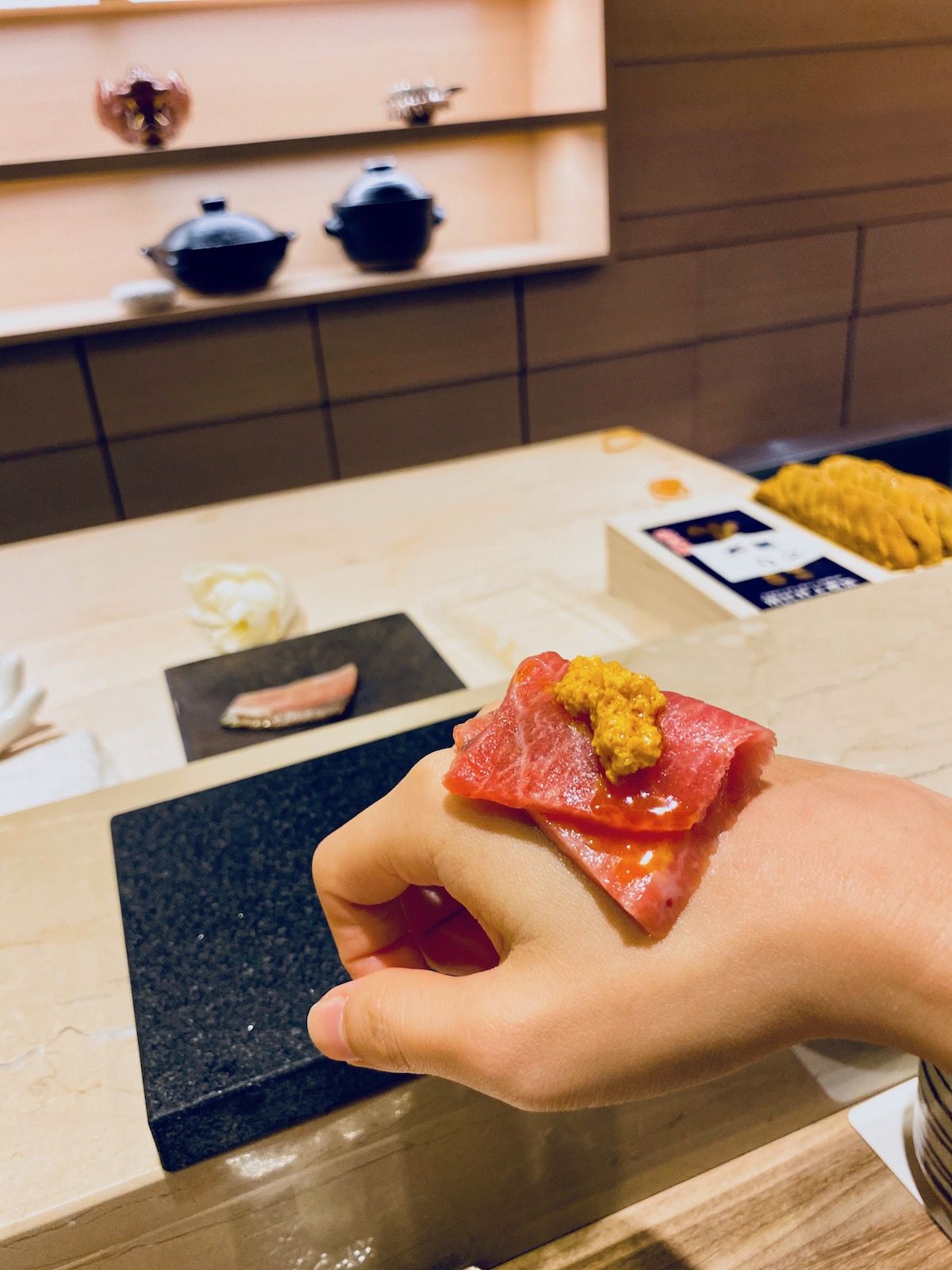 大閘蟹膏佐魚子醬黑鮪魚肚生魚片,需放在手上品嚐。