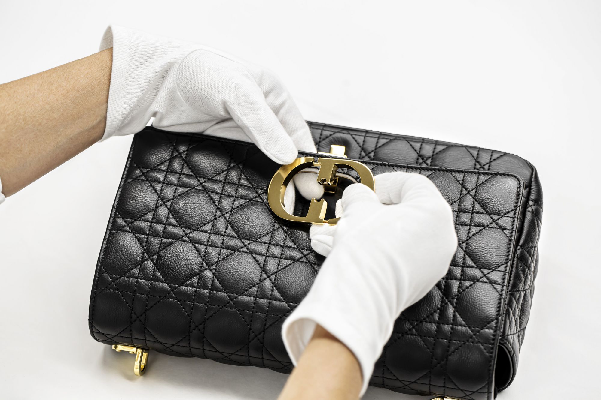 Dior Caro 包製作過程:裝上品牌縮寫金屬 CD 字樣開闔旋扣。