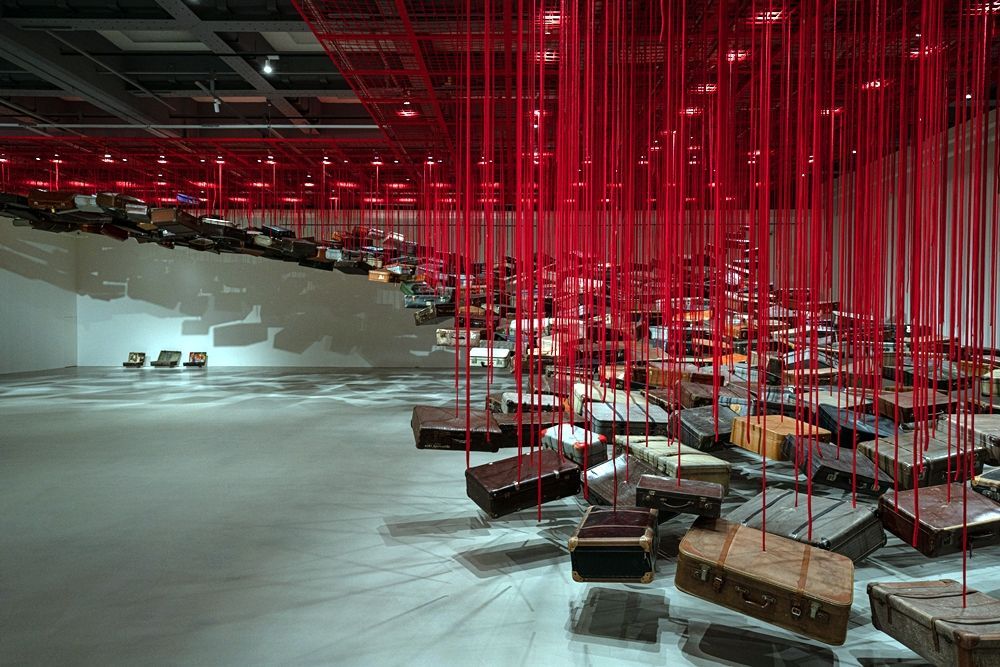 塩田千春,《集聚—找尋目的地》,2014/2021,行李箱、馬達、紅繩,尺寸依空間而定 Courtesy: Galerie Templon, Paris/ Brussels 展出現場:「塩田千春:顫動的靈魂」,臺北市立美術館,2021年。