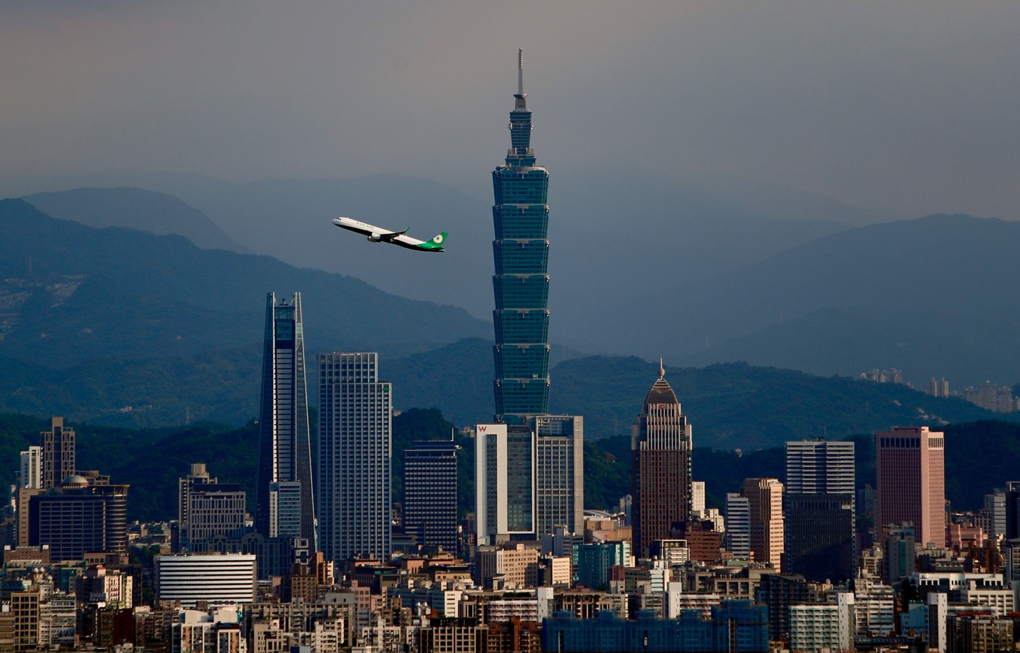 A domestic flight connecting Taipei City to Nangan Township departs from Songshan Airport and passes through in front of the Taipei 101 building, amid the spread of the Covid-19 pandemic, Taipei City, Taiwan, 12 July 2020.Unlike other countries like India and the United Kingdom where full and partial bans upon domestic flights have been in place , respectively since the pandemic started to spread, airlines for domestic travellers in Taiwan have not been affected as no suspension was stepped up by the govern