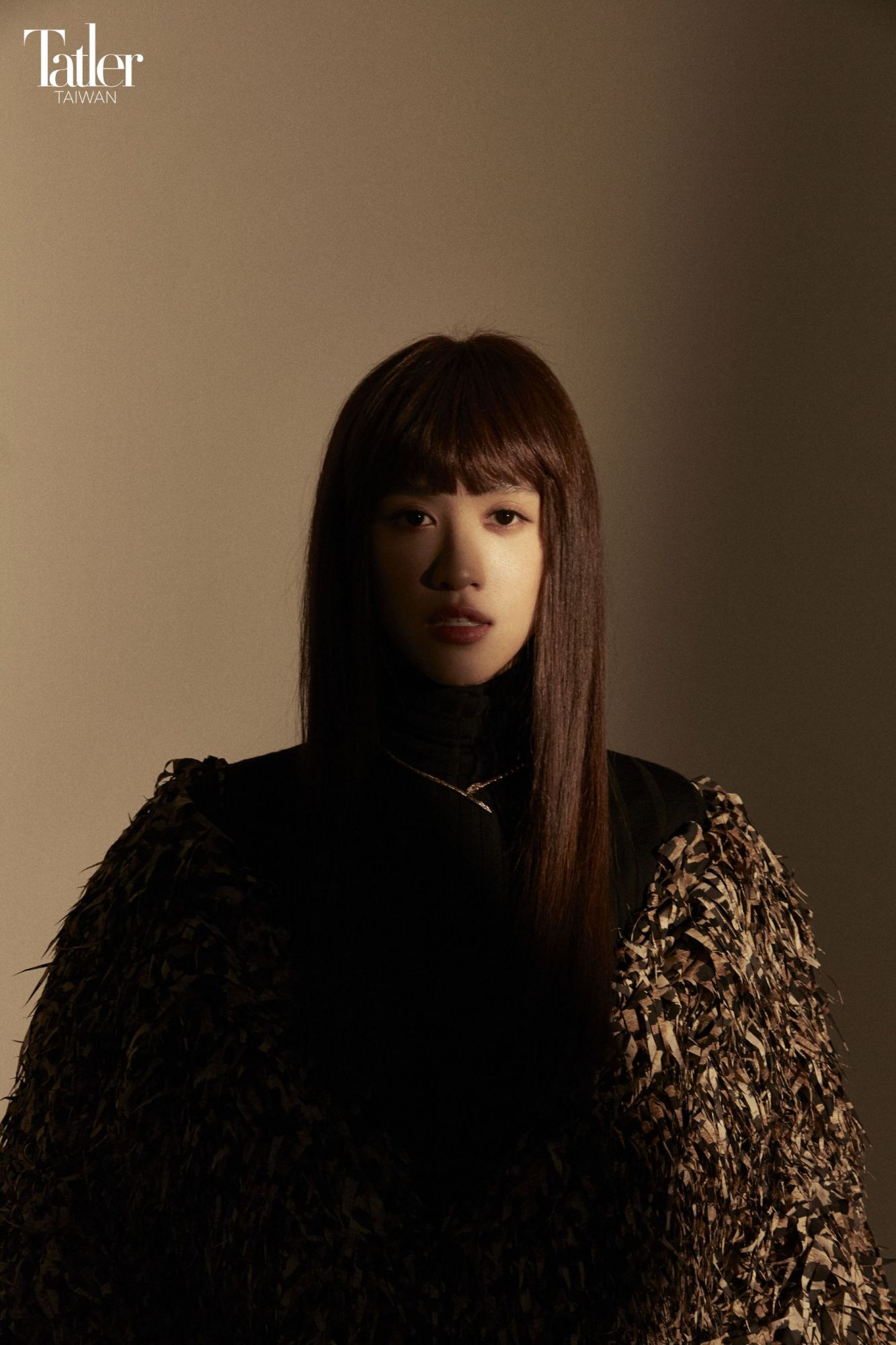 流蘇大衣(Balenciaga);針織高領上衣(Longchamp);Serpenti Viper 項鍊(Bulgari)。