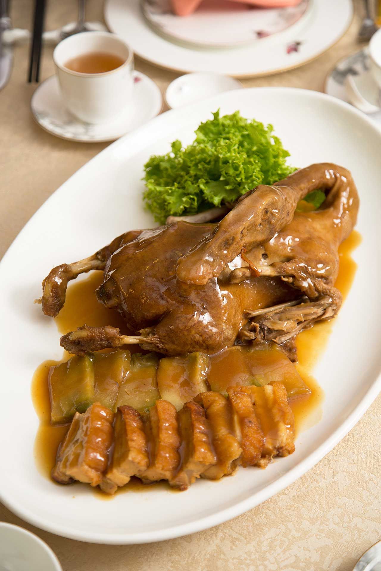 Braised whole duck with preserved vegetables and roast pork