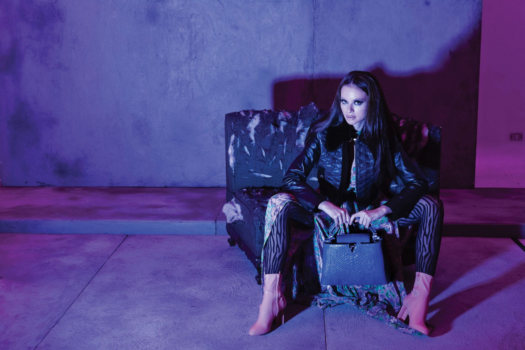 Valerie wears a puff leather jacket with detachable faux fur collar, printed long dress, patent silhouette ankle boots, and blue python Capucines bag, all from Louis Vuitton