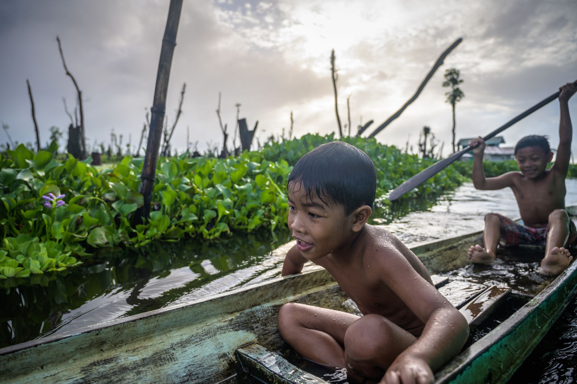 The indigenous youth of the Manobo Tribe casually playing with the traditional canoes of their parents. They usually play and swim in the lake of the marsh after taking classes in their floating school. A fewer and fewer indigneous youth are holding through this way of life as they are being forced to live more inland due to disasters brought about climate change.