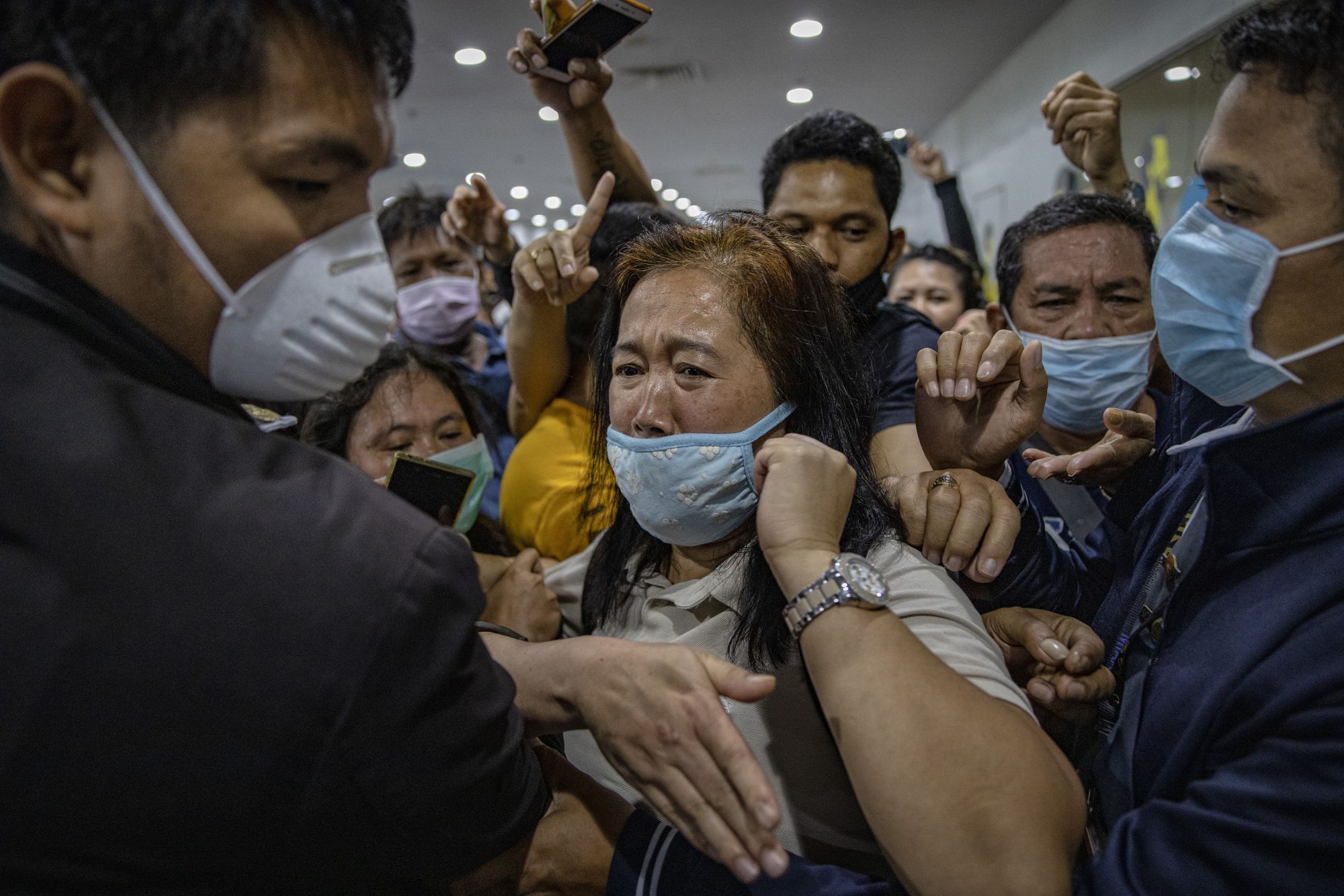 MANILA, PHILIPPINES - MARCH 14: Airport security staff attempt to control the crowd as Filipinos hoping to get on flights out of Manila hours before it is placed on lockdown queue at Ninoy Aquino International Airport on March 14, 2020 in Manila, Philippines. Philippine President Rodrigo Duterte announced on Thursday that he would place some 12 million people in the capital Manila on lockdown and suspend government work for a month to prevent the spread of COVID-19. The Philippines' Department of Health has